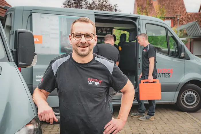 Elektromonteur am Servicefahrzeug beim Beladen von Werkzeug