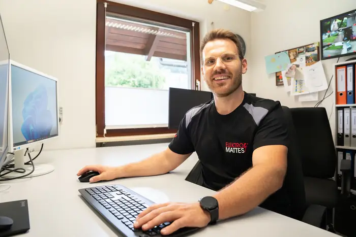 Mitarbeiter eines Elektrobetriebs bei der Büroarbeit am Rechner